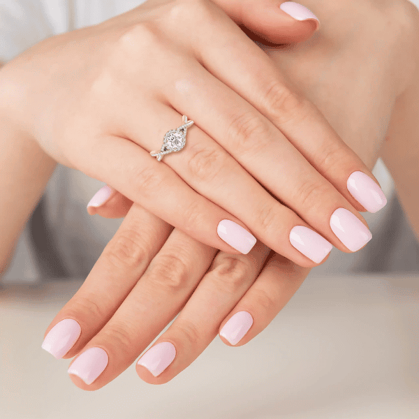A lady's folded hands with a round brilliant-cut diamond piece on her ring finger. Jose Jeweller's infinity style stackable ring.