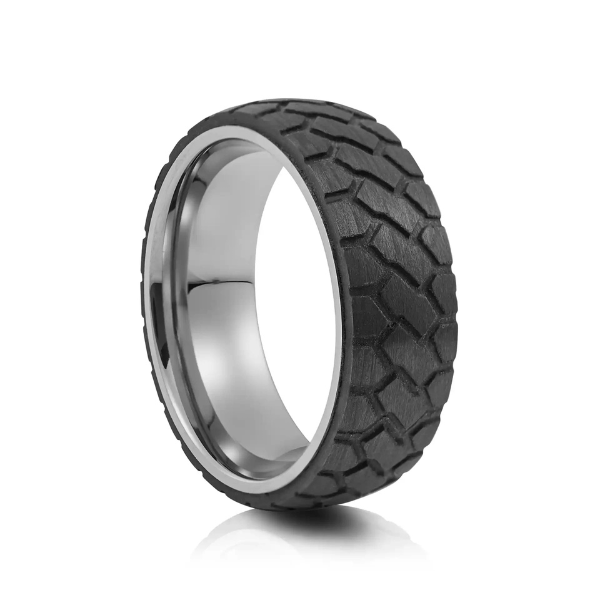 A pitch-black tire tread patterned ring with a silver tungsten core, showcasing unique men's wedding bands for surfers and trail runners.
