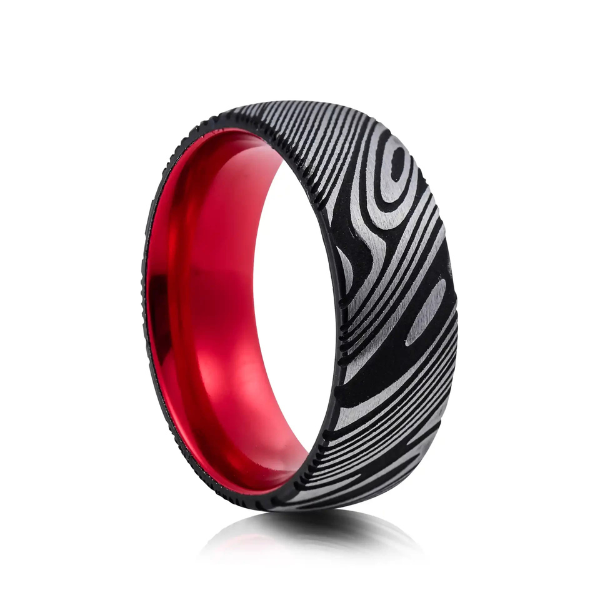 A striking black Damascus steel band exterior with a signature woodgrain pattern and vibrant red interior. Unique mens wedding band from Jose Jewellers.