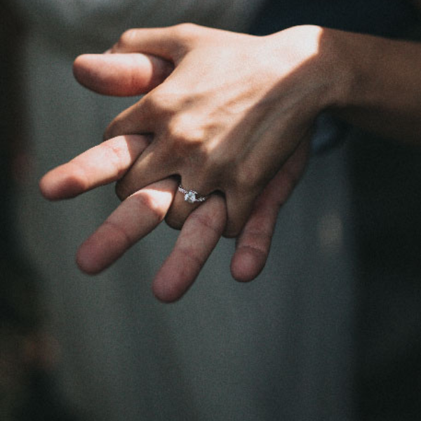 A recently wed Mzansi couple holding hands, showcasing a lab diamond ring alongside the groom’s hardworking hands.